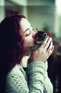 woman kissing kitten