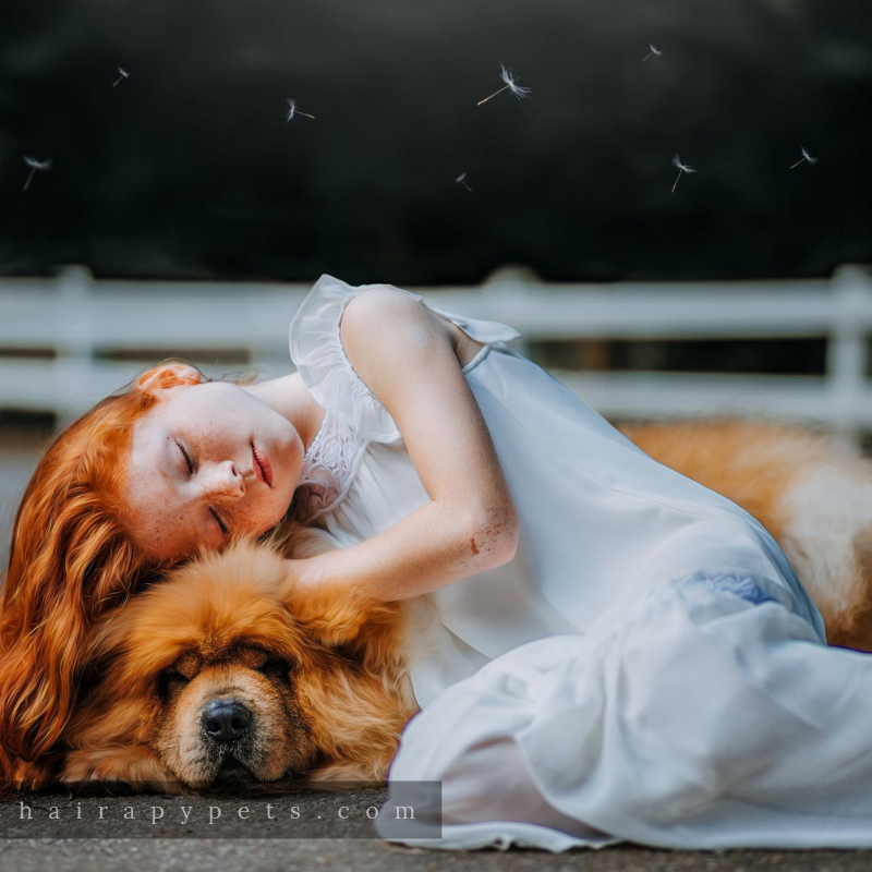 red headed girl with dog lying down
