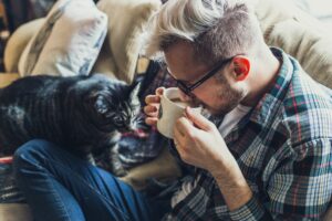 cat stepping on man's lap