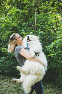 woman carrying large dog